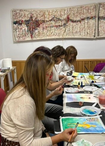 grupo de mujeres pintando juntas alrededor de una mesa en un encuentro creativo de Hechizarte en Madrid